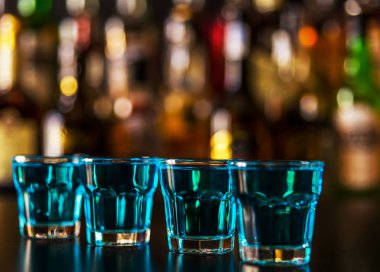 Popüler mavi içki şişeleri, serinletici içecek, gece parti ile çubuğunun arka plan üzerinde kamikaze vurdu