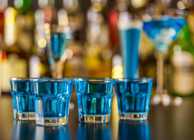 Popüler mavi içki şişeleri, serinletici içecek, gece parti ile çubuğunun arka plan üzerinde kamikaze vurdu