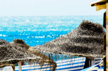 Güzel kumsalı ile palmiye ağacı şemsiye ve mavi deniz, tatil