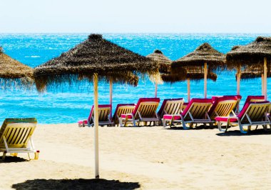 Güzel kumsalı ile palmiye ağacı şemsiye ve mavi deniz, tatil