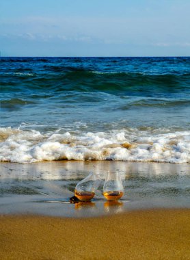 bardak viski kum üzerinde tek malt dalgalar, tatma, bir cam tarafından yıkanmış rahatlayın plajda tatil