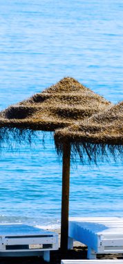 Güzel kumsalı ile palmiye ağacı şemsiye ve mavi deniz, tatil