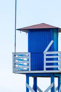 Mavi kurtarma kulübe güvenli bir kumlu plajda sakin okyanus, güzel bir güneşli gün, tatil