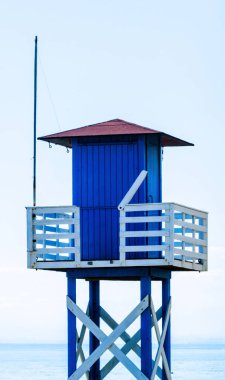 Mavi kurtarma kulübe güvenli bir kumlu plajda sakin okyanus, güzel bir güneşli gün, tatil