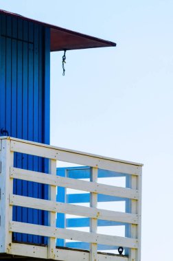 Mavi kurtarma kulübe güvenli bir kumlu plajda sakin okyanus, güzel bir güneşli gün, tatil