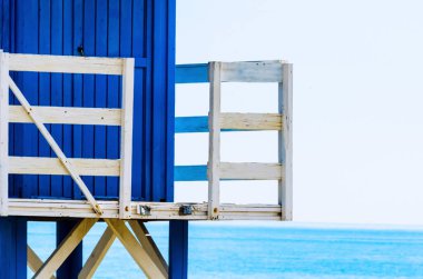 Mavi kurtarma kulübe güvenli bir kumlu plajda sakin okyanus, güzel bir güneşli gün, tatil