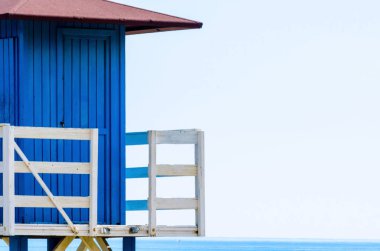 Mavi kurtarma kulübe güvenli bir kumlu plajda sakin okyanus, güzel bir güneşli gün, tatil