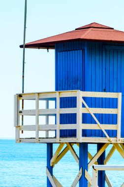 Mavi kurtarma kulübe güvenli bir kumlu plajda sakin okyanus, güzel bir güneşli gün, tatil