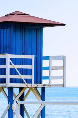 Mavi kurtarma kulübe güvenli bir kumlu plajda sakin okyanus, güzel bir güneşli gün, tatil