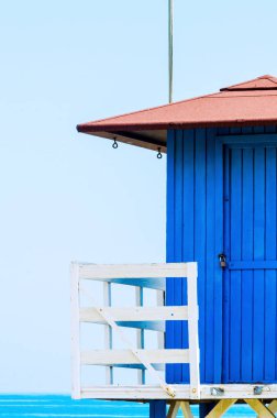 Mavi kurtarma kulübe güvenli bir kumlu plajda sakin okyanus, güzel bir güneşli gün, tatil