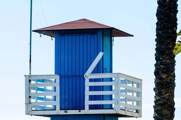 Mavi kurtarma kulübe güvenli bir kumlu plajda sakin okyanus, güzel bir güneşli gün, tatil