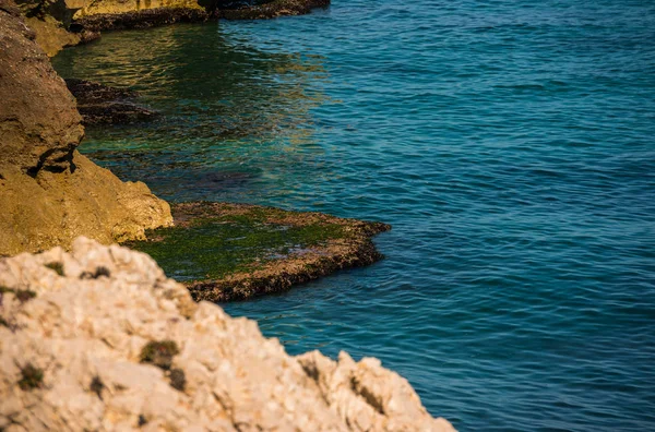 high cliff above the sea, summer sea background, many splashing waves and stone, sunny day