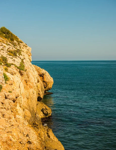 high cliff above the sea, summer sea background, many splashing waves and stone, sunny day