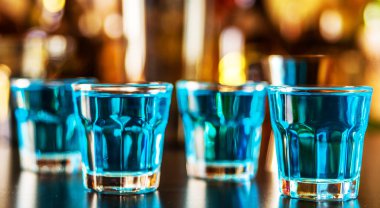 Popüler mavi içki şişeleri, serinletici içecek, gece parti ile çubuğunun arka plan üzerinde kamikaze vurdu