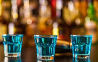 Popüler mavi içki şişeleri, serinletici içecek, gece parti ile çubuğunun arka plan üzerinde kamikaze vurdu