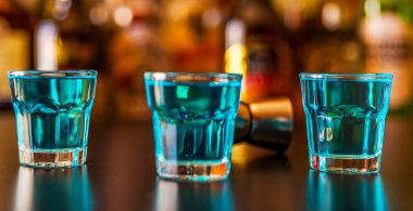 Popüler mavi içki şişeleri, serinletici içecek, gece parti ile çubuğunun arka plan üzerinde kamikaze vurdu