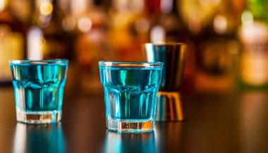 Popüler mavi içki şişeleri, serinletici içecek, gece parti ile çubuğunun arka plan üzerinde kamikaze vurdu