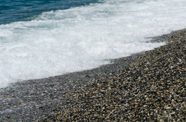 dalgalar deniz, küçük ve çeşitli taşlar sahile doğa şekillendirme tarafından yıkanmış Çakıl Plajı