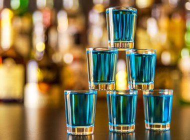 Popüler mavi içki şişeleri, serinletici içecek, gece parti ile çubuğunun arka plan üzerinde kamikaze vurdu