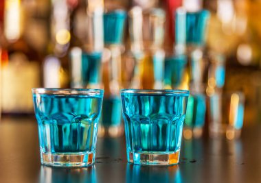 Popüler mavi içki şişeleri, serinletici içecek, gece parti ile çubuğunun arka plan üzerinde kamikaze vurdu