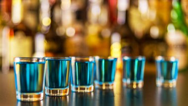 Popüler mavi içki şişeleri, serinletici içecek, gece parti ile çubuğunun arka plan üzerinde kamikaze vurdu