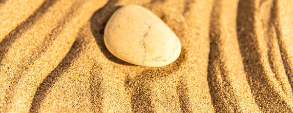 zen meditation stone in sand, concept for purity harmony and spirituality, spa wellness and yoga background, harmony