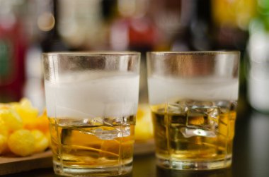 viski buz küpleri ve bar, parti zamanı ve şişeler ve arka plan üzerinde tuzlu atıştırmalıklar ile cam