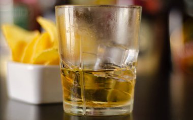 viski buz küpleri ve bar, parti zamanı ve şişeler ve arka plan üzerinde tuzlu atıştırmalıklar ile cam