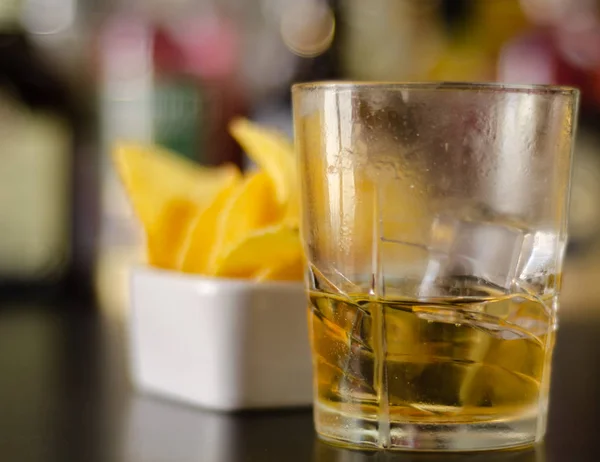 Glas Whisky Met Ijsblokjes Zoute Snacks Achtergrond Van Flessen Bar — Stockfoto