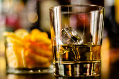 bardak viski buz küpleri ve bar, arka plan üzerinde tuzlu atıştırmalıklar ile parti zamanı