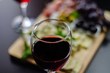 Kırmızı şarap ve bir tahta masa, lezzetli Aperatif, sağlıklı ve özel gıda üzerinde farklı peynir kümesi