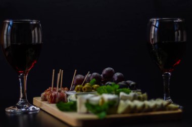 Kırmızı şarap ve bir tahta masa, lezzetli Aperatif, sağlıklı ve özel gıda üzerinde farklı peynir kümesi