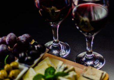 Kırmızı şarap ve bir tahta masa, lezzetli Aperatif, sağlıklı ve özel gıda üzerinde farklı peynir kümesi