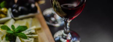 Kırmızı şarap ve bir tahta masa, lezzetli Aperatif, sağlıklı ve özel gıda üzerinde farklı peynir kümesi