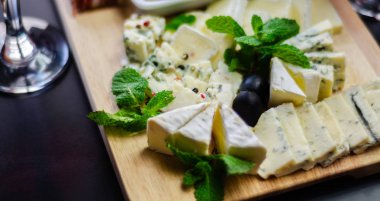 Tahtadaki farklı peynirler, peynir tahtası, lezzetli atıştırmalıklar, sağlıklı ve özel yemekler, peynir takımı.