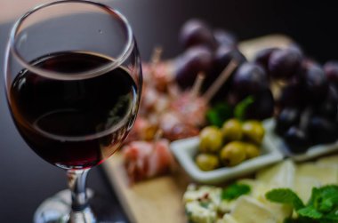 Kırmızı şarap ve bir tahta masa, lezzetli Aperatif, sağlıklı ve özel gıda üzerinde farklı peynir kümesi