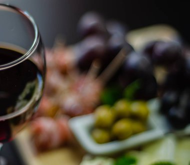 Kırmızı şarap ve bir tahta masa, lezzetli Aperatif, sağlıklı ve özel gıda üzerinde farklı peynir kümesi