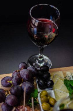Kırmızı şarap ve bir tahta masa, lezzetli Aperatif, sağlıklı ve özel gıda üzerinde farklı peynir kümesi