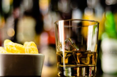 bardak viski buz küpleri ve bar, arka plan üzerinde tuzlu atıştırmalıklar ile parti zamanı