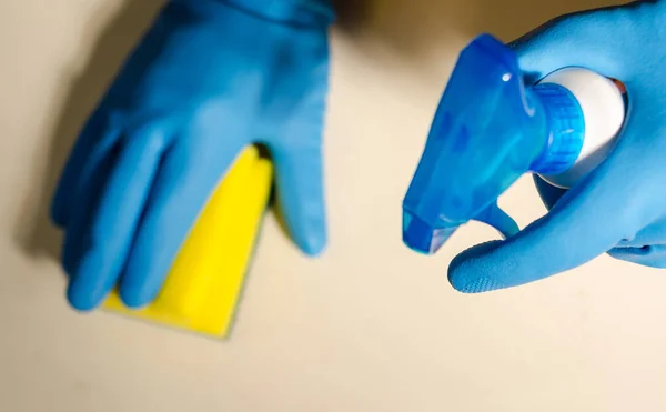 hands in rubber gloves cleaning the surfaces of ceramic tiles, safe and hygienic cleaning, keeping the house clean