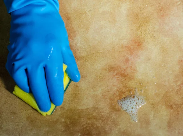 hands in rubber gloves cleaning the surfaces of ceramic tiles, safe and hygienic cleaning, keeping the house clean
