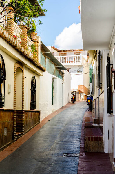 Beautiful and picturesque narrow street with white facades of buildings, Spanish architecture, old town