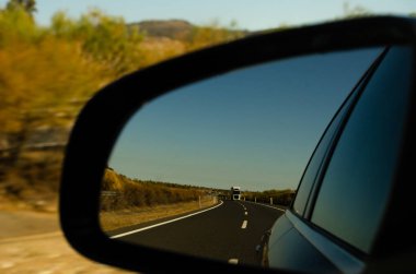İspanya 'da araba aynasında hızlı yol manzarası, güzel manzara, ulaşım.