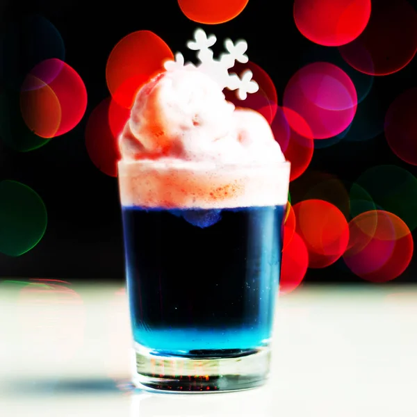 Christmas drink shot in a shot glass on a bokeh background, Christmas decoration on the bar, xmas party