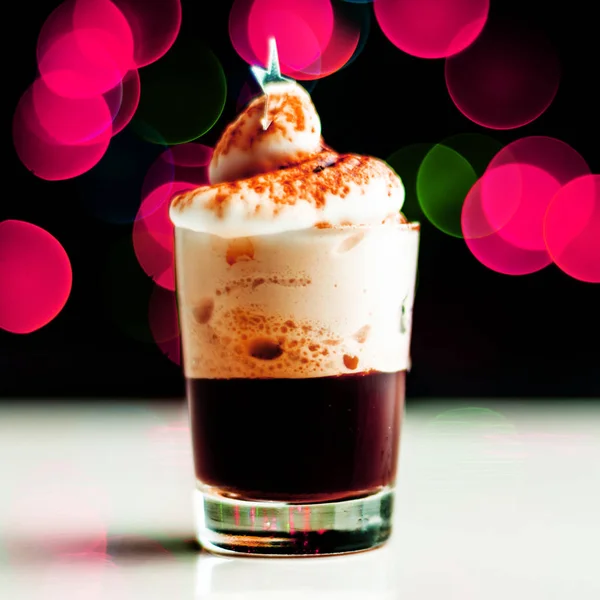 Christmas drink shot in a shot glass on a bokeh background, Christmas decoration on the bar, xmas party