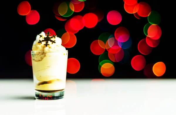 Christmas drink shot in a shot glass on a bokeh background, Christmas decoration on the bar, xmas party