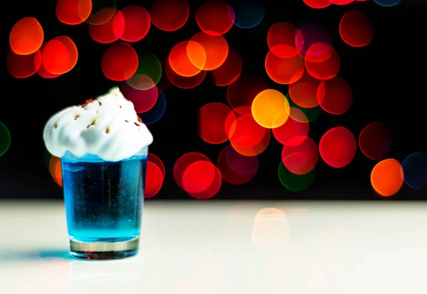 Christmas drink shot in a shot glass on a bokeh background, Christmas decoration on the bar, xmas party