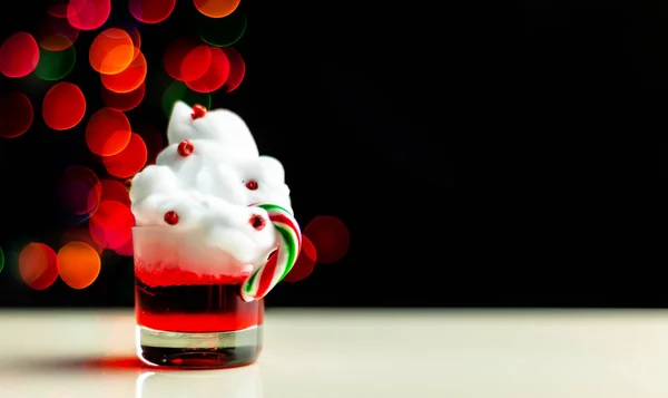 Christmas drink shot in a shot glass on a bokeh background, Christmas decoration on the bar, xmas party