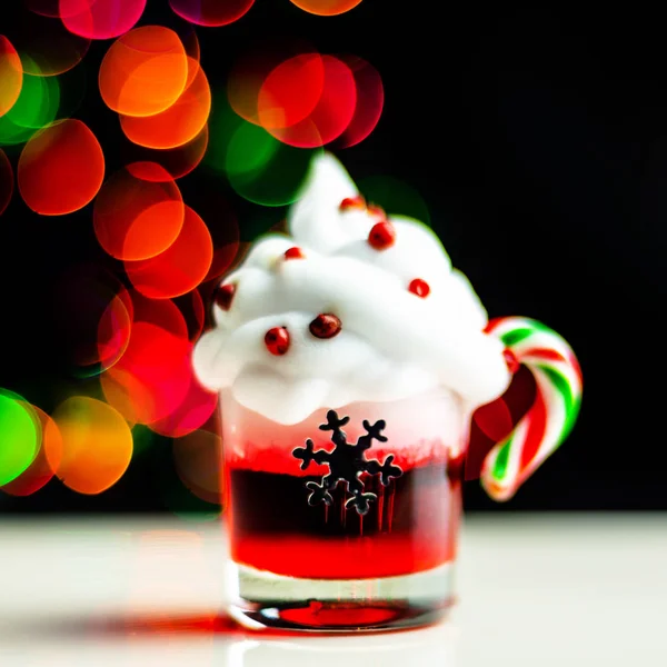 Christmas drink shot in a shot glass on a bokeh background, Christmas decoration on the bar, xmas party