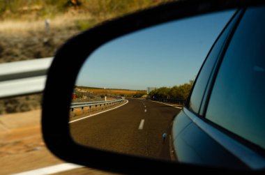 İspanya 'da araba aynasında hızlı yol manzarası, güzel manzara, ulaşım.